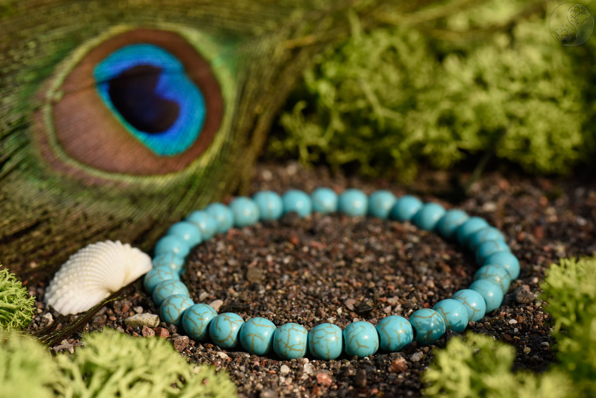 Armband mit Heilsteinperlen aus türkis auf schwarzem Sand
