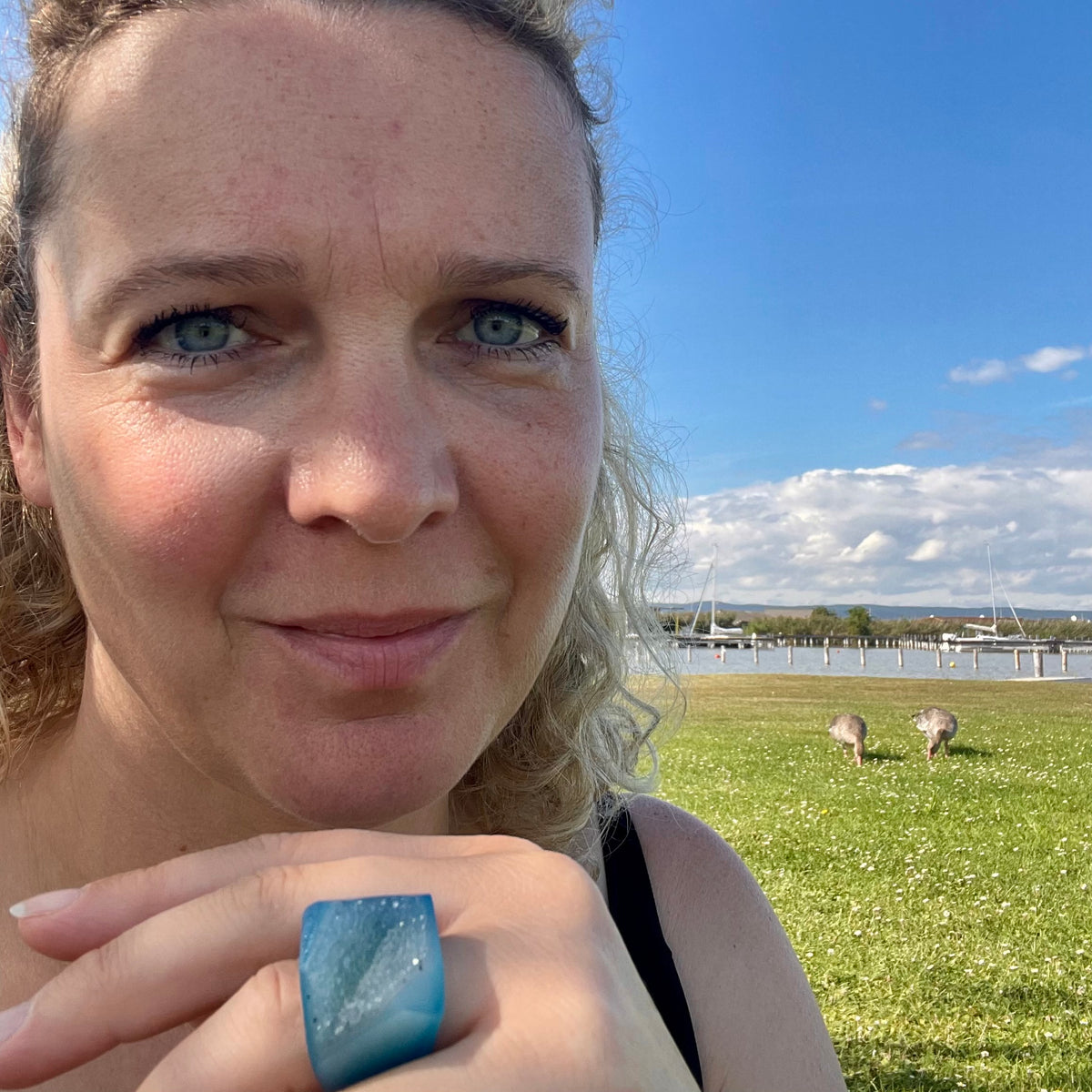 Nahaufnahme einer Frau, hält Hand mit einem Achat Ring am Finger in die Kamera