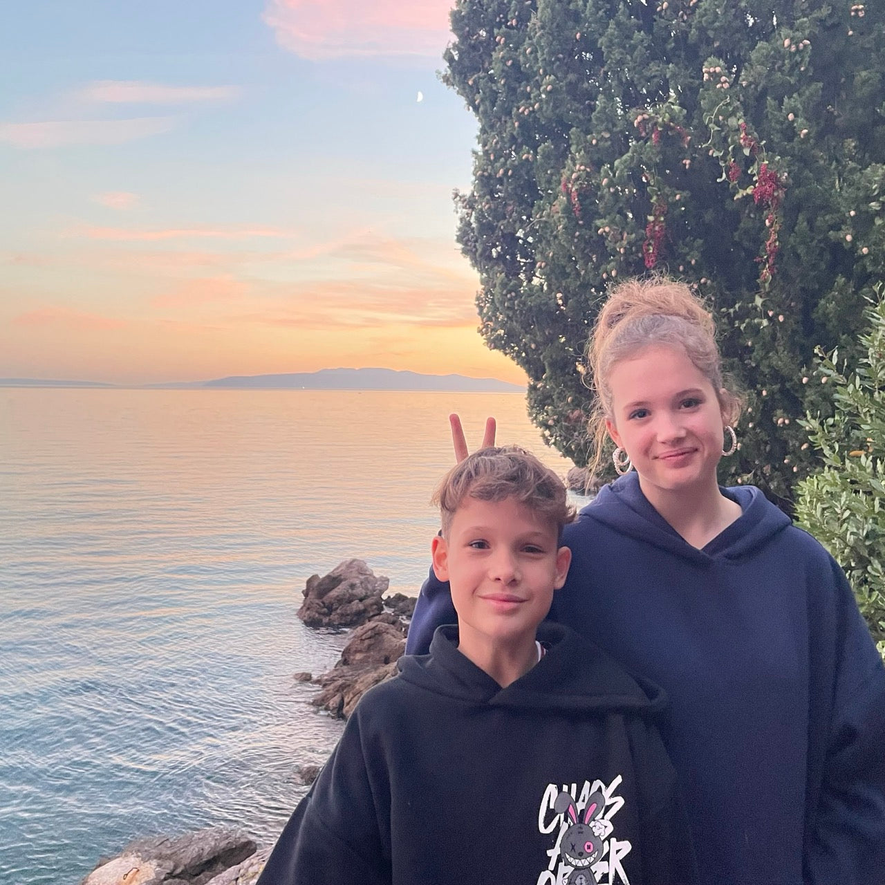 Junge und Mädchen vor dem Meer bei Sonnenuntergang